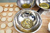 Olivenöl, das beim Brotbacken in eine Schüssel gegossen wird