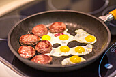 Mini Hamburgers and Quail Eggs Frying in Pan
