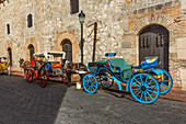 Bemalte Pferdekutschen warten auf Fahrgäste in der alten Kolonialstadt Santo Domingo, Dominikanische Republik. UNESCO-Weltkulturerbe der Kolonialstadt Santo Domingo.
