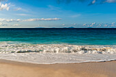 Die Brandung des Indischen Ozeans brandet an einen tropischen Sandstrand. Strand Anse Macquereau, Insel Fregate, Seychellen.