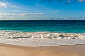 Indian Ocean surf surging onto a sandy tropical beach. Anse Macquereau Beach, Fregate Island, Seychelles.