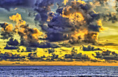 Das goldene Licht der wirbelnden Wolken bei Sonnenuntergang spiegelt sich in einem rosafarbenen Schimmer am Strand von Pererenan Beach, Bali, Indonesien