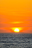 Das goldene Licht der untergehenden Sonne reflektiert einen goldenen Schimmer auf dem Strand von Pererenan Beach, während die Wellen auf Bali, Indonesien, anrollen