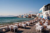 Tische im Restaurant am Meer im Stadtteil Klein-Venedig. Chora, Insel Mykonos, Kykladeninseln, Griechenland.