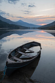 Ireland, Lake Cummeenduff. Partially submerged boat on lake.