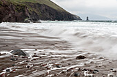 Ireland, County Kerry, Dunmore Head. Cliff and wave on ocean and beach.