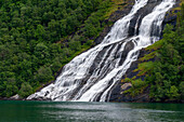 Seven Sisters waterfalls plunges off sheer cliffs into Geirangerfjord, Norway.