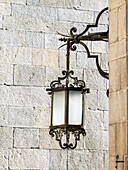 Old street lamp hanging in the streets of Santiago de Compostela.