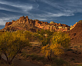 USA, Utah, Capital Reef National Park. Sunrise on mountain formations and trees.