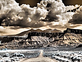 USA, Utah. Infrarot der Straße, die zum Fisher Tower führt, und große Wolken