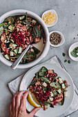 Top view of anonymous person putting slice of fresh lemon on plate with lentil salad over gray table