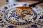 Leckere süße gebackene Pfannkuchen auf weißem und blauem Teller mit Gabel auf dem Tisch im Tageslicht