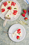 Scheibe eines leckeren süßen gebackenen Käsekuchens mit reifen Erdbeeren auf einem weißen Teller auf einem Tisch in einer hellen Küche