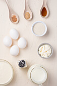 Draufsicht auf ein Layout mit verschiedenen Zutaten für die Zubereitung eines leckeren Omeletts auf weißem Hintergrund in einem Studio