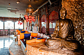 Interior of cocktail bar with Buddha statue and cozy couches designed in oriental style
