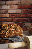 Delicious wholegrain bread on cutting board on table