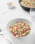 Nahaufnahme eines Tellers mit Bulgur-Quinoa-Bohnen auf einem weißen Tisch