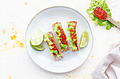 Kleine leckere Tacos mit rotem Kaviar und grünem Salat, serviert auf einem hölzernen Schneidebrett auf dem Tisch
