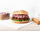 Leckerer veganer Pilz-Hamburger mit Salat und Kopfsalat im Brötchen mit Mohn auf dem Tisch