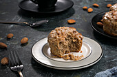 Leckerer gesunder Kaffee-Keto-Muffin mit Glasur serviert auf weißem Teller auf Tisch mit Besteck in heller Küche