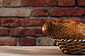 Seitenansicht eines leckeren geschnittenen Brotes mit brauner Kruste und knusprigen Sonnenblumenkernen in einem Weidenkorb