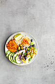 Draufsicht auf Teller mit köstlichen frischen Apfel- und Limettenscheiben neben Süßkartoffelspalten und Oliven mit Hummus auf dem Tisch
