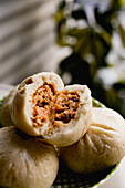 Steamed baozi cut in half against blurred background