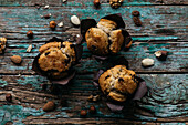 Close-up view from above of three homemade muffins with chocolate and nuts