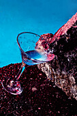 From above glass of Blue Lagoon alcoholic cocktail placed on rough stone in bright studio