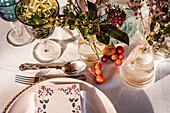 High angle of served festive table with crystal glasses cutlery napkin on plate near bunch of fresh flowers for wedding and menu card