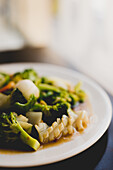 White ceramic plate with broccoli and squid meal