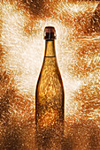 Feine Champagnerflasche, umgeben von glänzenden, funkelnden Lichtern und auf orangefarbenem Hintergrund platziert