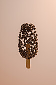 Side view of a surreal ice cream made up of chocolate balls suspended in the air