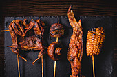 From above composition of tasty grilled skewers with meat, fish, squid and broccoli in cafe