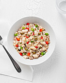 Nahaufnahme eines Tellers mit Bulgur-Quinoa-Bohnen auf einem weißen Tisch