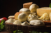 Sammlung von italienischem Käse auf dem Tisch mit frischem Gemüse und krauser Petersilie mit Basilikumblättern auf Spateln