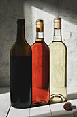 Komposition köstlicher halbsüßer Rot- und Weißweine in Flaschen auf einem Brettertisch
