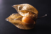 Top view of exotic orange Peruvian groundcherry placed on black table in studio
