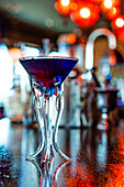 Blick von unten auf einen erfrischenden Flavor-Blaster-Cocktail im Glas, der auf dem Tresen einer Bar serviert wird