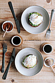 Appetizing slice of grain bread with avocado and poached egg on top placed on plate on wooden table
