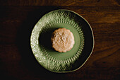 Ornamental plate with glutinous rice cake placed on lumber tabletop in cafe