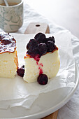 Delicious slices of baked cheesecake topped with berry jam served on a plate