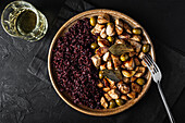 Von oben gesehen runder Teller mit schmackhaftem sautiertem Truthahn mit Oliven neben einem Glas Getränk auf einem schwarzen Tisch im Restaurant