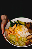 Von oben betrachtet hält eine Frau ein leckeres taiwanesisches Bento auf einem Holztisch in einem asiatischen Cafe