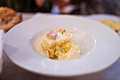From above of appetizing saucy pasta with boiled egg served in plate in restaurant