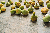 Ripe sweet green figs, freshly harvested from domestic tree, on table with grunge texture. Also known as ripe white figs