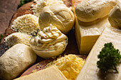 Sammlung italienischer Käsesorten im Ganzen und gerieben auf einem Holztisch