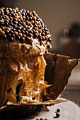 Sweet homemade baked panettone on round wooden stand for celebrating Christmas