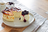 Delicious slices of baked cheesecake topped with berry jam served on a plate