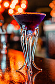 Blick von unten auf einen erfrischenden Flavor-Blaster-Cocktail im Glas, der auf dem Tresen einer Bar serviert wird